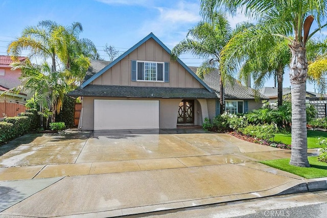 view of front of property with board and batten siding, an attached garage, a shingled roof, and concrete driveway