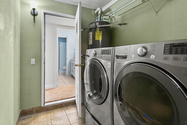 laundry room featuring laundry area, washing machine and clothes dryer, tile patterned flooring, and water heater