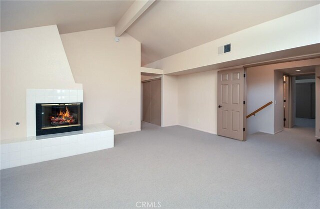 unfurnished living room featuring visible vents, lofted ceiling with beams, carpet, and a fireplace