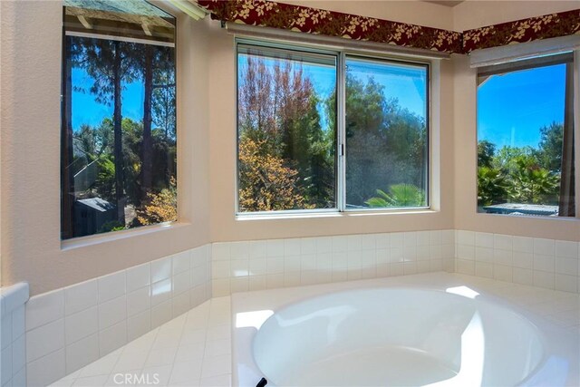 full bath featuring a garden tub and a wealth of natural light