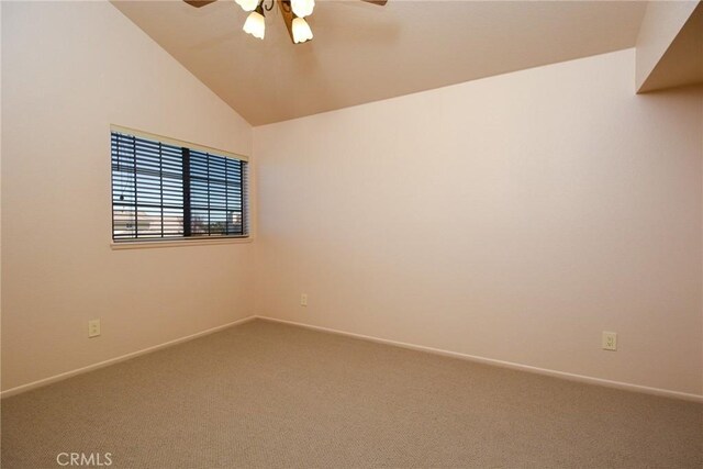 spare room featuring carpet floors, ceiling fan, vaulted ceiling, and baseboards