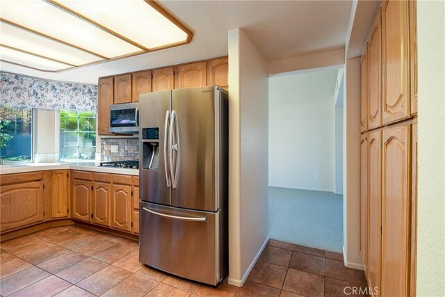 kitchen featuring light countertops, stainless steel appliances, and light tile patterned floors