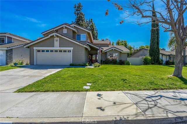 traditional-style house with a garage, fence, driveway, and a front yard