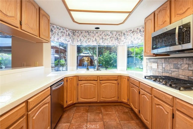 41768 Via El Greco, Temecula, CA 92592 - kitchen featuring appliances with stainless steel finishes, a sink, light countertops, tasteful backsplash, and dark tile patterned floors