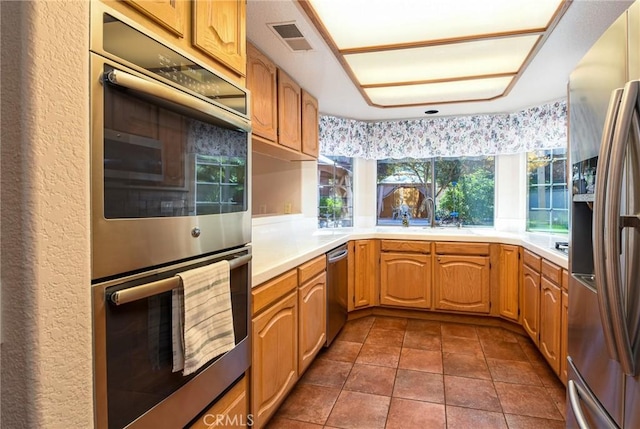41768 Via El Greco, Temecula, CA 92592 - kitchen featuring appliances with stainless steel finishes, light countertops, a sink, and dark tile patterned flooring