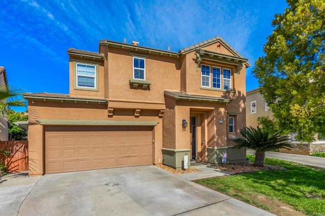 view of front of property with driveway, stucco siding, fence, and an attached garage