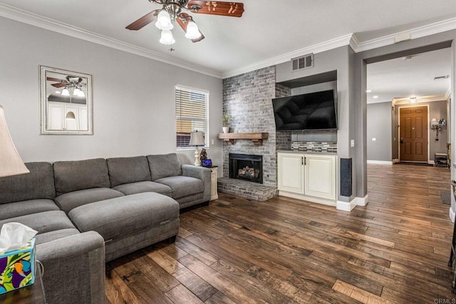 living room featuring dark wood-style floors, ornamental molding, a ceiling fan, and visible vents