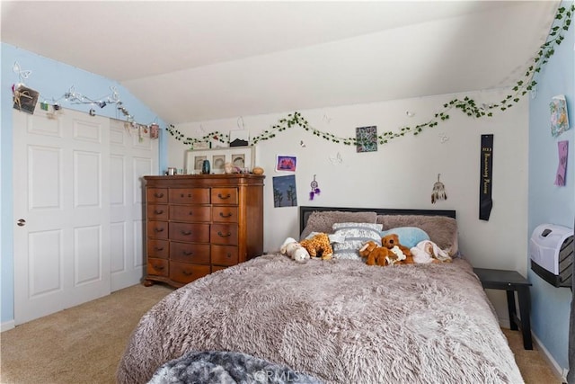 bedroom featuring a closet, light colored carpet, and vaulted ceiling