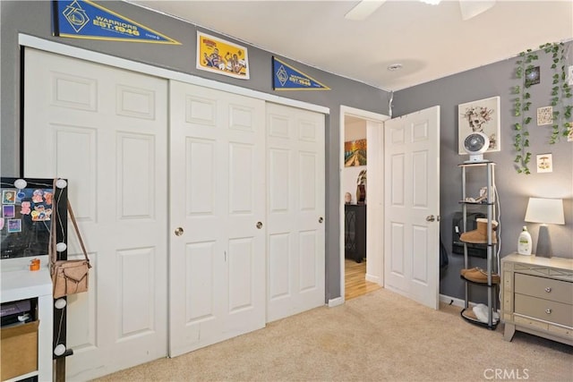carpeted bedroom with a closet and a ceiling fan