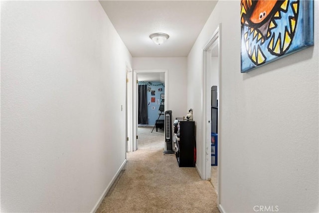 hall featuring light carpet and baseboards