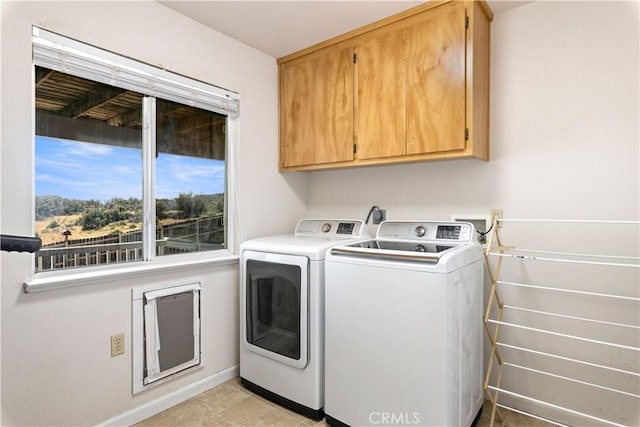 laundry area with independent washer and dryer, baseboards, and cabinet space