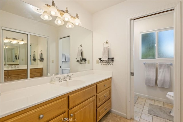 full bathroom with toilet, vanity, and baseboards
