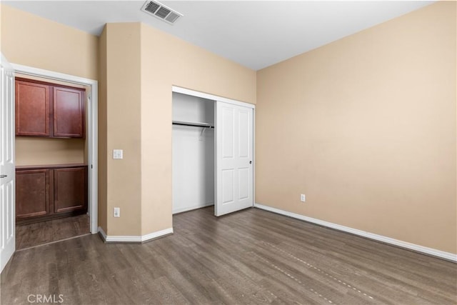 17938 Caraway Ct, San Bernardino, CA 92407 - unfurnished bedroom featuring a closet, dark wood-style flooring, baseboards, and visible vents