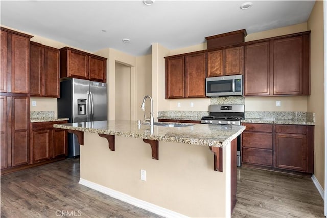 17938 Caraway Ct, San Bernardino, CA 92407 - kitchen featuring appliances with stainless steel finishes, wood finished floors, a sink, and an island with sink