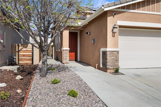 17938 Caraway Ct, San Bernardino, CA 92407 - doorway to property with fence, a garage, stucco siding, and stone siding