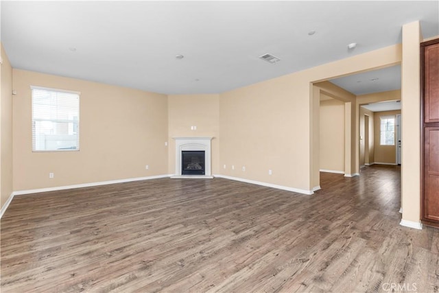 17938 Caraway Ct, San Bernardino, CA 92407 - unfurnished living room with visible vents, baseboards, a glass covered fireplace, and wood finished floors