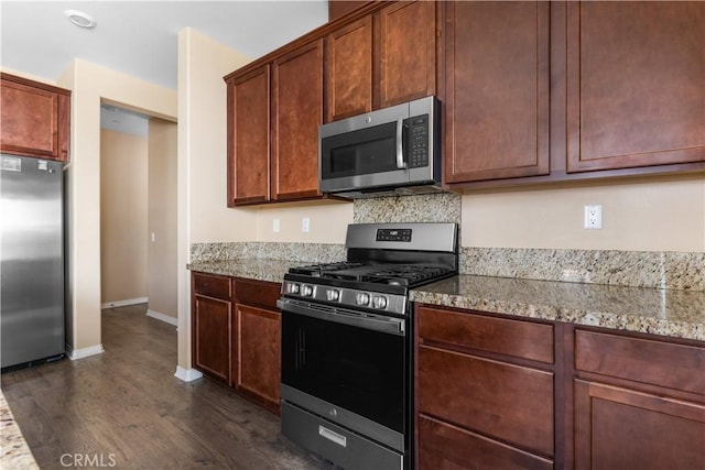 17938 Caraway Ct, San Bernardino, CA 92407 - kitchen featuring appliances with stainless steel finishes, light stone counters, dark wood-style floors, and baseboards
