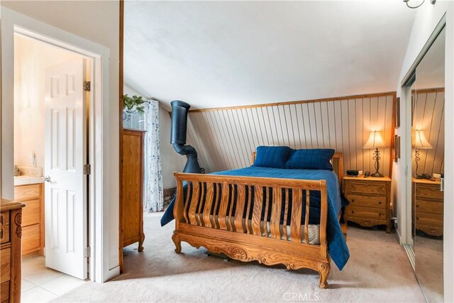 bedroom with light carpet and ensuite bath