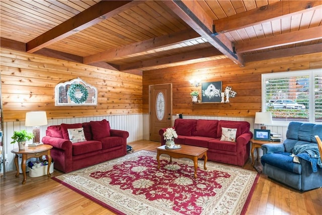 living room with wood-type flooring, wood ceiling, a healthy amount of sunlight, and beamed ceiling