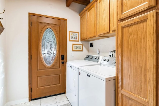 laundry room with cabinet space, light tile patterned floors, and washer and clothes dryer