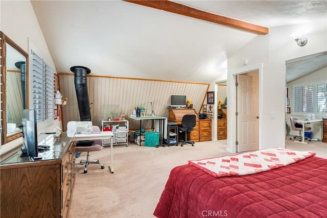 bedroom featuring lofted ceiling with beams, carpet flooring, and a wood stove