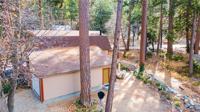 view of property exterior with roof with shingles