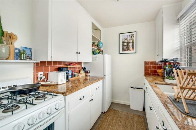 kitchen with white appliances, white cabinetry, and tasteful backsplash