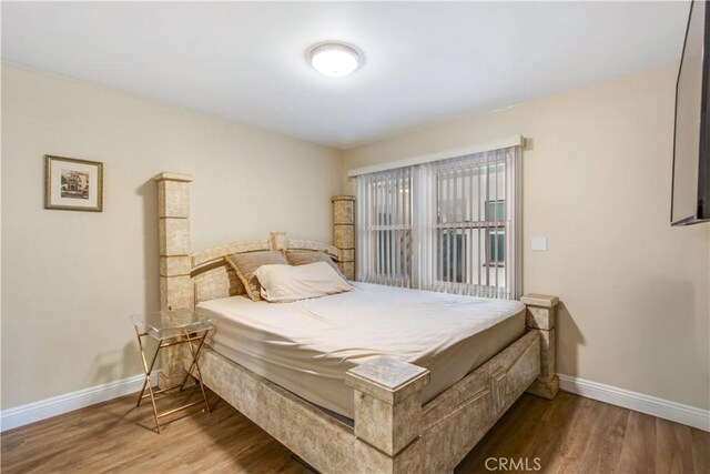 bedroom with baseboards and wood finished floors