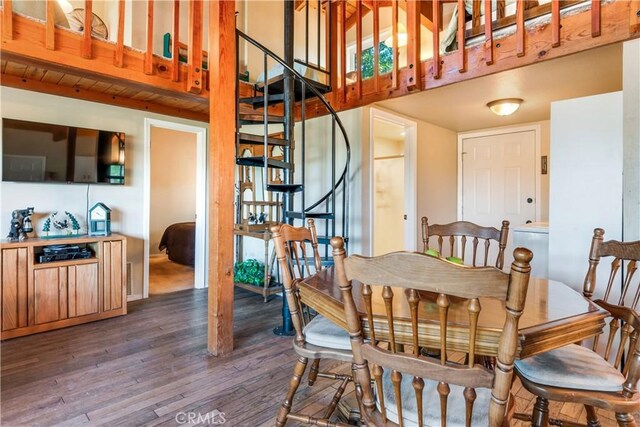 dining room featuring a high ceiling, stairs, and wood finished floors