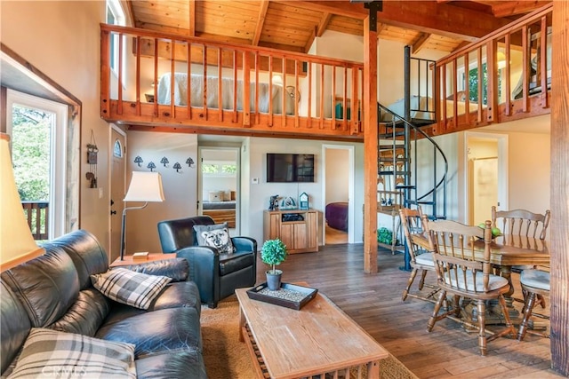 living area with a healthy amount of sunlight, high vaulted ceiling, hardwood / wood-style flooring, and stairs