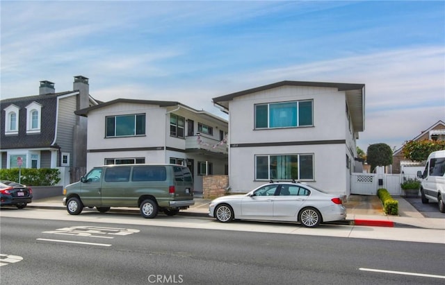 view of front of house featuring fence and stucco siding