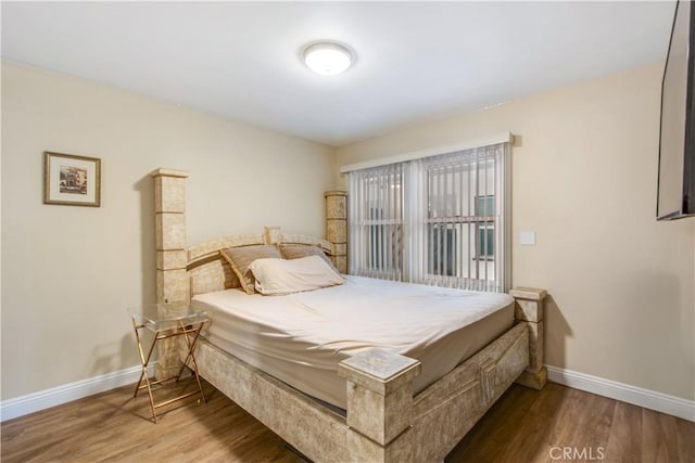 bedroom with wood finished floors and baseboards