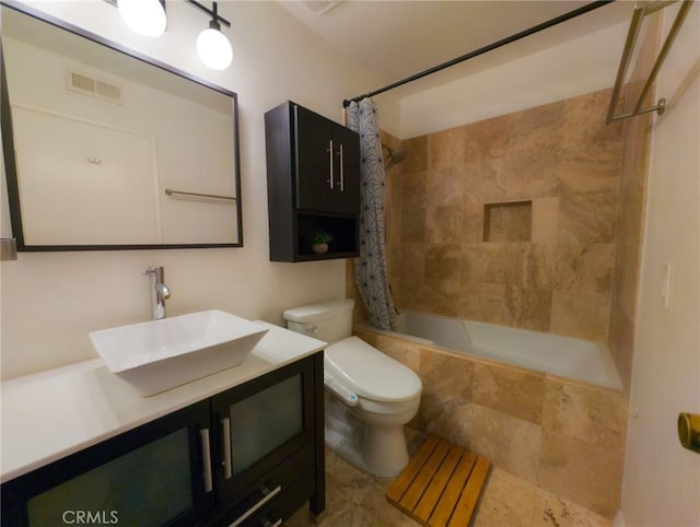 full bathroom with toilet, tiled shower / bath combo, visible vents, and vanity