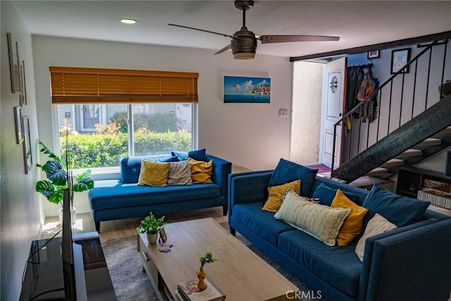 living area featuring recessed lighting, a ceiling fan, and stairs