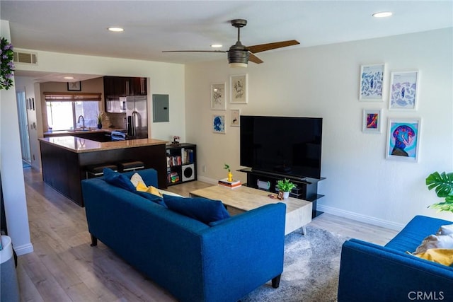 54 Oval Rd Unit 3, Irvine, CA 92604 - living area featuring ceiling fan, electric panel, wood finished floors, recessed lighting, and baseboards