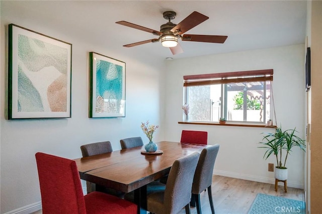 dining room with baseboards, light wood-type flooring, and ceiling fan