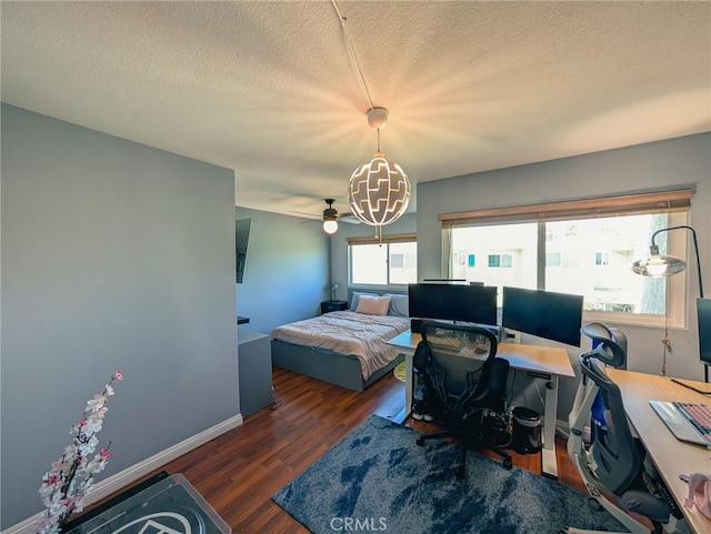 bedroom with a textured ceiling, wood finished floors, and baseboards