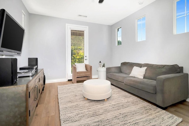 living area featuring visible vents, baseboards, and light wood-style floors