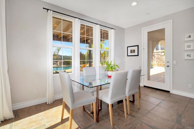 tiled dining space with baseboards and recessed lighting
