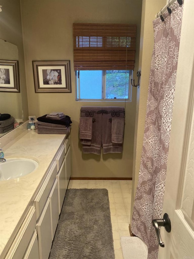 bathroom featuring baseboards, a shower with shower curtain, and vanity