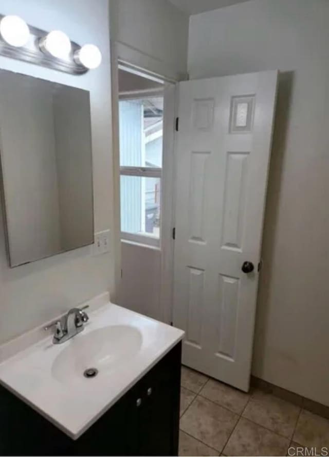 bathroom featuring tile patterned floors, baseboards, and vanity