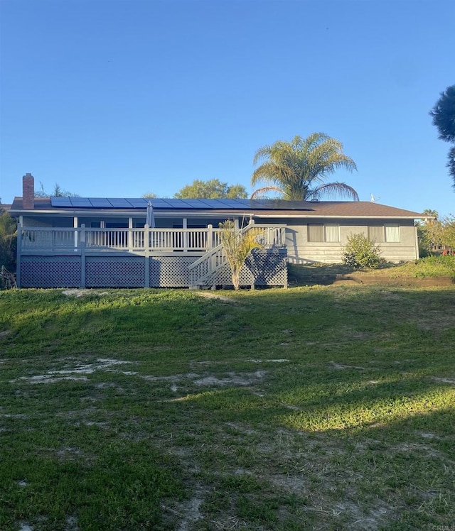 554 Taylor St, Vista, CA 92084 - rear view of house with roof mounted solar panels, a deck, a yard, and a chimney