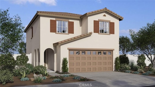 mediterranean / spanish home featuring concrete driveway, stucco siding, an attached garage, a tiled roof, and fence