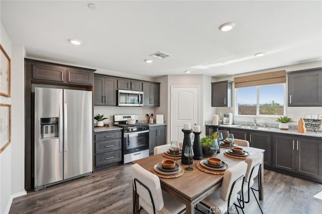 kitchen featuring dark brown cabinets, visible vents, recessed lighting, dark wood-style flooring, and stainless steel appliances
