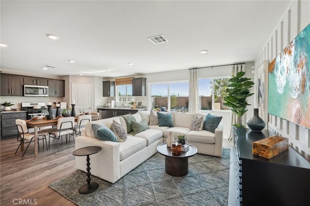 living area featuring wood finished floors, visible vents, and recessed lighting