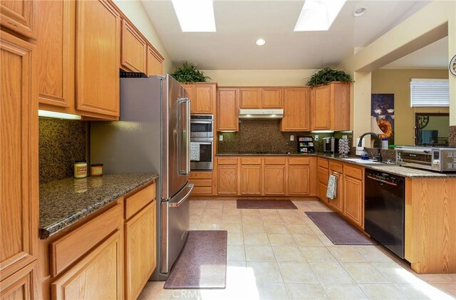 24182 Via Llano, Murrieta, CA 92562 - kitchen with stainless steel appliances, under cabinet range hood, a sink, a skylight, and tasteful backsplash