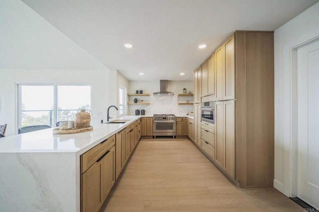kitchen with light countertops, open shelves, wall chimney exhaust hood, stainless steel appliances, and a sink