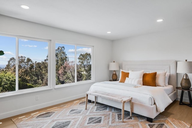 bedroom with recessed lighting, wood finished floors, and baseboards