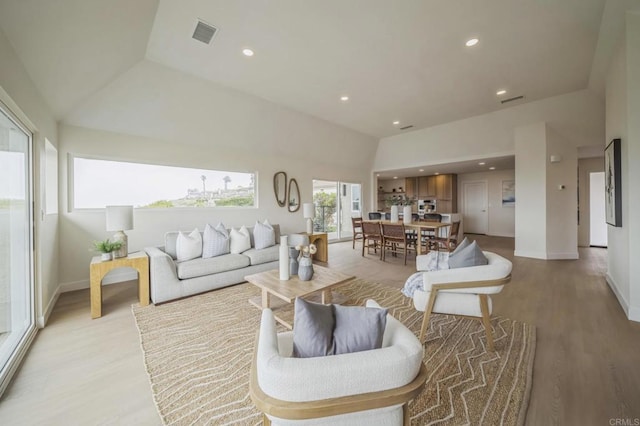 living room featuring light wood finished floors, baseboards, visible vents, and recessed lighting