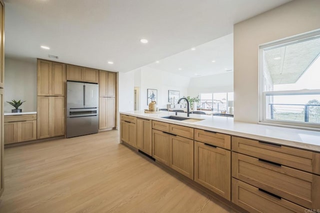 kitchen with light wood-style floors, freestanding refrigerator, a sink, and recessed lighting